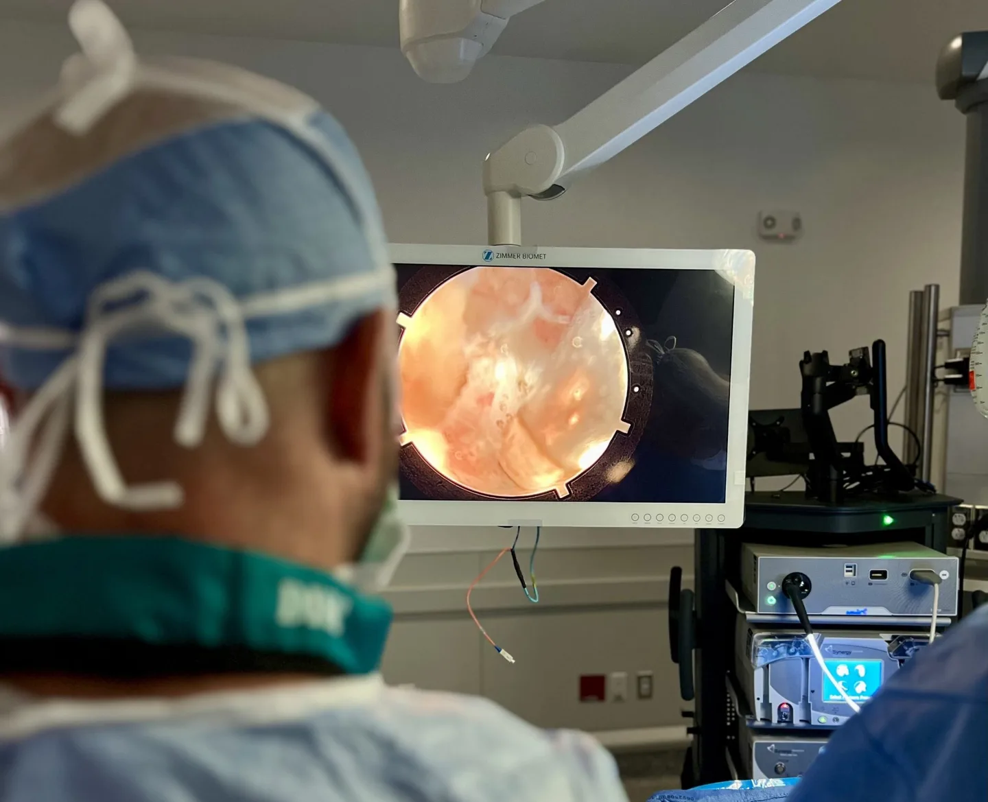 Dr. Brandon Hirsch performing endoscopic spine surgery while viewing the endoscopic field on a surgical monitor